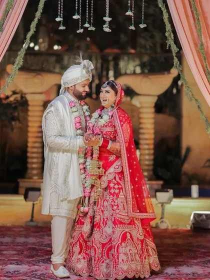 A joyful, candid moment between the bride and groom during the Varmala ceremony. Their laughter and expressions capture the happiness and excitement of officially becoming partners.