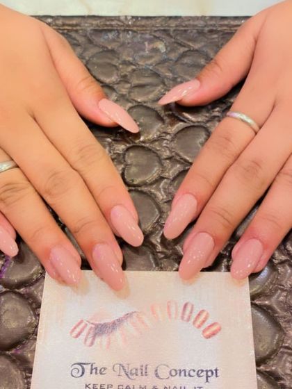 A beautiful set of long, almond-shaped nails in a sheer, natural-looking pink. This is a perfect choice for an elegant, "your nails but better" look.