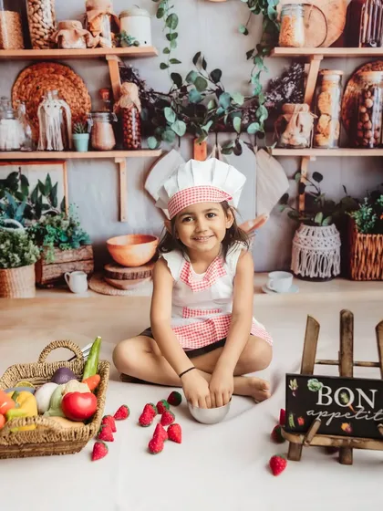 A perfect portrait of a happy little chef, ready for her culinary adventure.