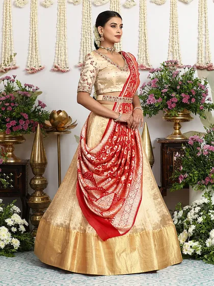 A different styling for the gold lehenga, featuring a draped red Banarasi dupatta for a more classic, South Indian bridal look.