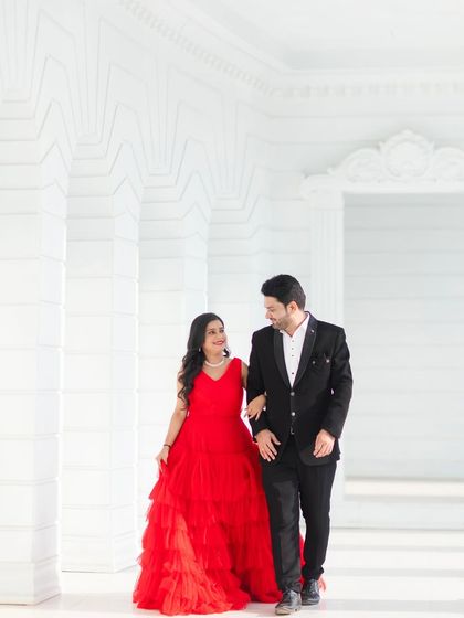 A sweet, walking shot through a white corridor set. This captures a natural and happy interaction between the couple.