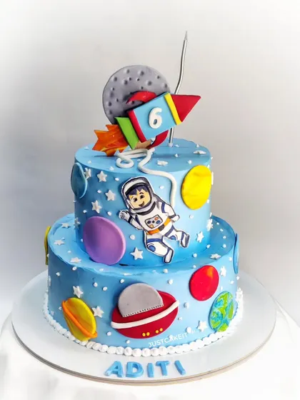 This two-tiered space and planets theme cake features a hand-painted astronaut and semi-fondant accents. It was paired with vanilla blueberry cupcakes for a complete out-of-this-world birthday party.