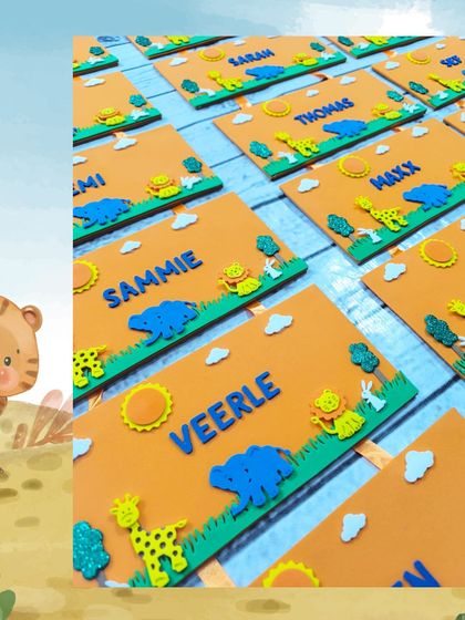 A detailed shot of the handcrafted jungle nameplates, showing the foam animal cutouts and personalized names.