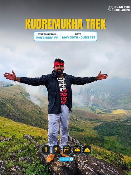A trekker with arms wide open at the summit of Kudremukha, embracing the vast, rolling green hills. This trek is one of Karnataka's most beautiful and rewarding adventures.