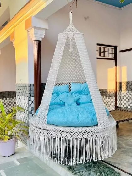 This high-quality white swing with a sky-blue mattress looks fresh and inviting on this beautiful tiled porch.