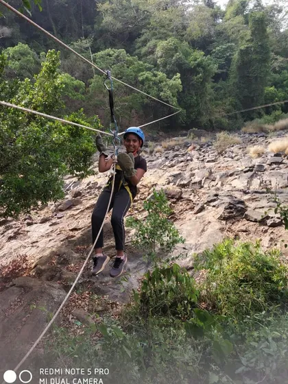 A young girl enjoys the rope bridge activity, safely harnessed and supervised by our team.