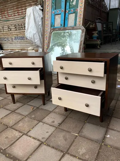 A pair of two-tone mid-century modern bedside tables with the drawers open to show the solid wood construction. The contrast between the dark-stained frame and the light-colored drawer fronts is a key design feature.