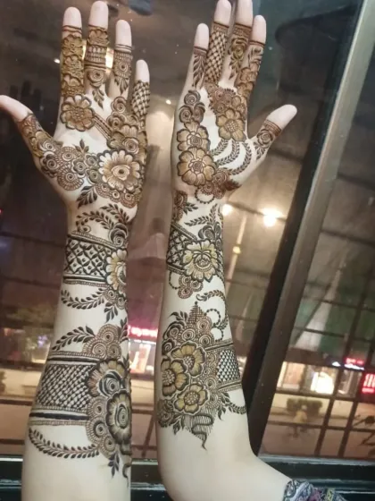 A semi-bridal design with beautiful floral bands on the forearms and flowing patterns on the hands. The contrast between dark and light henna is lovely.