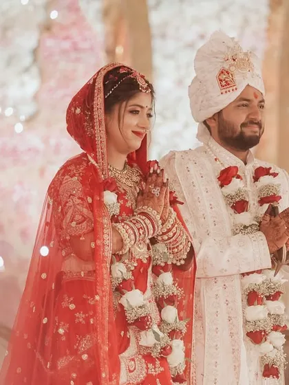 The couple stands together, hands joined in prayer, as sparklers light up the background. This shot captures the feeling of a consecrated love, blessed by sacred fire and the good wishes of their loved ones.