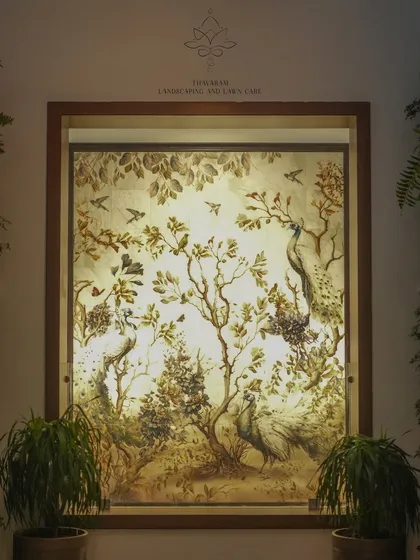 This backlit mural depicts a classic scene of peacocks and birds in a forest, framed like a window. It serves as a beautiful piece of art that brings nature indoors.