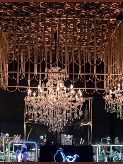 A custom-designed bar area with a gold metallic ceiling and multiple crystal chandeliers, creating a focal point of glamour and opulence.