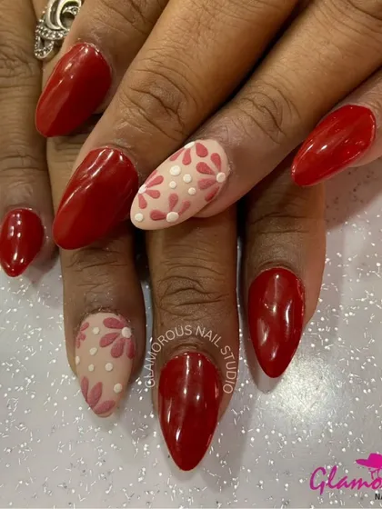 A classic combination of red and nude. We paired glossy red nails with accent nails featuring a delicate, hand-painted floral pattern in shades of red and pink on a nude base.