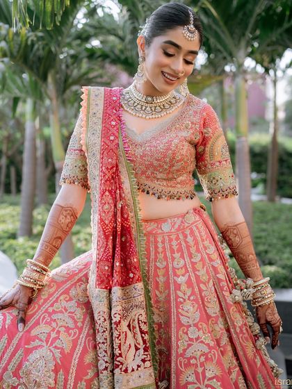 The bride admiring the intricate details of her beautiful lehenga. Her smile says it all.
