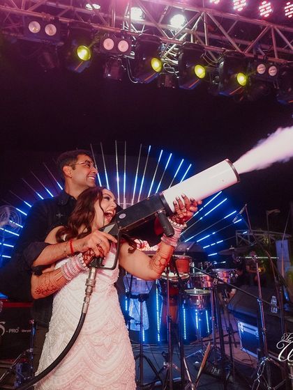 The bride taking control of the CO2 cannon at her after-party, a moment of pure, explosive fun.