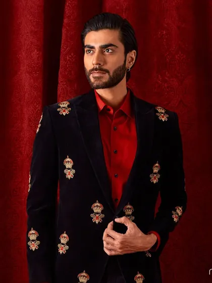 A powerful look for the festive season. This black velvet blazer is adorned with repeating crown motifs, each hand-embroidered to create a truly regal and commanding presence.
