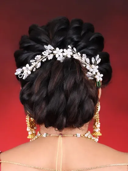 A detailed shot of the elegant bridal updo, adorned with a beautiful hair accessory. We teach these styles in our pro course.