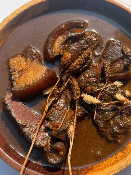 Our Smoked Pork Anishi curry. The intense flavor of the smoked pork blends perfectly with the earthy, dark Anishi curry, creating a dish that is rich in both taste and tradition.