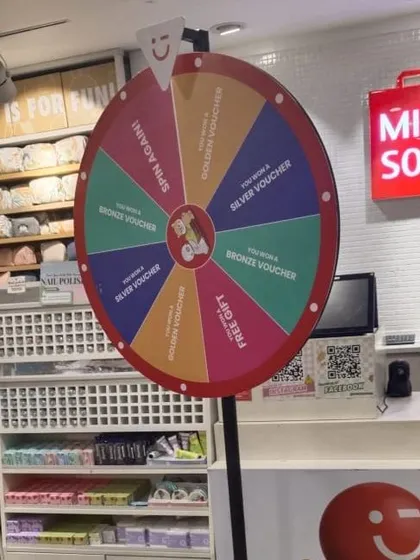 A "Spin the Wheel" prize game set up inside a retail store for a promotional event. This is an excellent tool for customer engagement and giveaways.