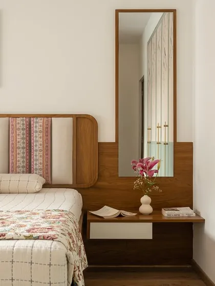 A detail shot of the 'Palaash' master bedroom wardrobe, showing the custom-designed brass handles against the sage-toned PU finish and wallpapered panels.