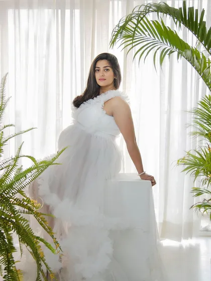 My Noida studio is a versatile space where we can create bright, fresh, and modern maternity portraits. The use of natural elements like these plants, paired with a beautiful white ruffled gown, creates an atmosphere that is both angelic and full of life.