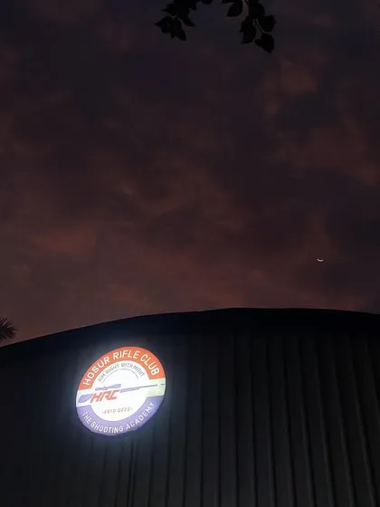 Our facility stands as a beacon for aspiring shooters in Hosur. The Hosur Rifle Club sign lights up our modern shooting academy, welcoming members day and night.