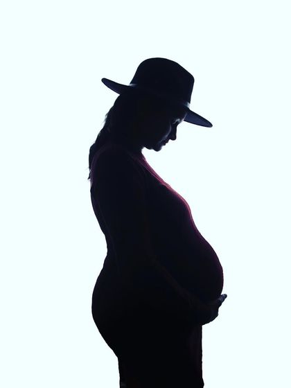 A stylish silhouette portrait featuring a fedora hat. Using simple props can add a touch of personality and flair to these artistic and moody shots.