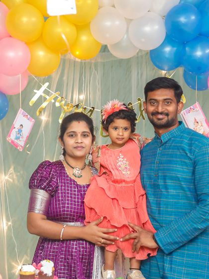 A beautiful family portrait under a colorful balloon arch.