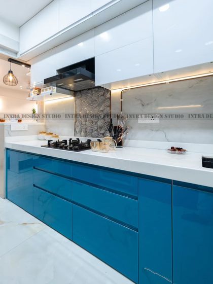Functionality is key in our kitchen designs. This shot highlights the clean lines of the handleless drawers, the built-in hob, and the durable white countertop, providing ample space for meal preparation.