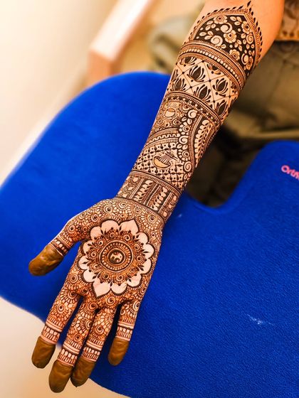 The fresh, natural brown color of my organic henna paste, featuring a central mandala on the palm and detailed work up the arm.