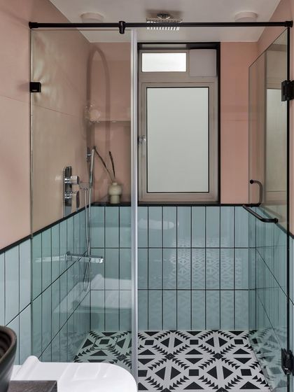 The daughters had a fun request for their bathroom: something quirky. We used patterned black and white tiles for the floor, with mint subway tiles on one wall and blush pink on the other, creating a unique and playful design.