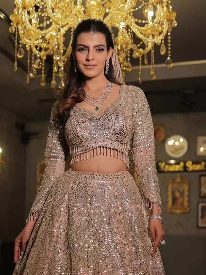 A trending mirror-work lehenga that catches the light beautifully. This shot under a chandelier highlights the incredible sparkle and craftsmanship.