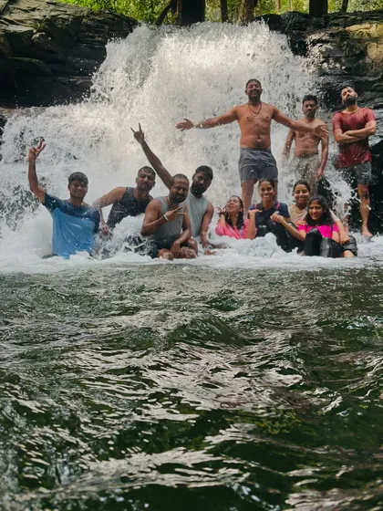 A happy group enjoying a dip in a waterfall after the strenuous Kumara Parvatha trek.