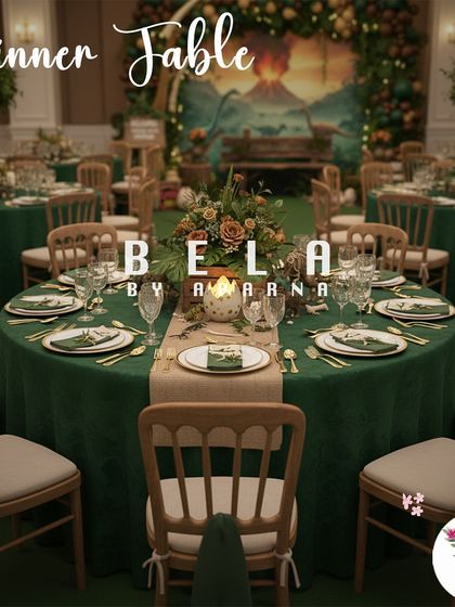 A guest table at the Jurassic party, featuring a deep green tablecloth and a simple, elegant centerpiece. The setup maintains a sophisticated feel while tying into the theme with its color palette and a view of the main stage in the background.