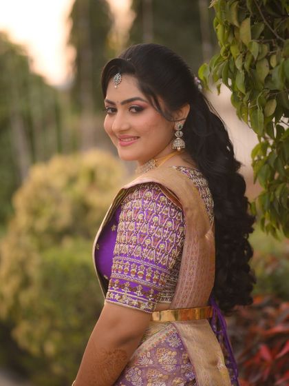 A beautiful portrait of the bride, her purple blouse and gold saree creating a stunning color combination.