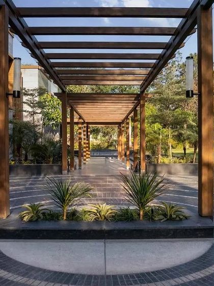 The wooden pergola walkway at the farmhouse entrance. This structure not only provides a sheltered path but also creates a beautiful play of light and shadow, guiding visitors toward the home.