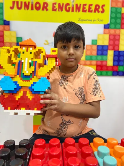 A young boy holds his colorful LEGO Ganesha, a testament to the hands-on learning and fun at our workshops.