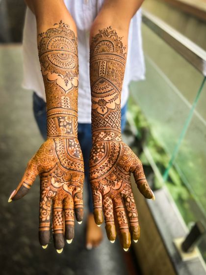 Another view of the engagement henna, showing the full design on both arms.