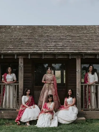 An editorial-style group photo of the bride and her bridesmaids in front of a rustic cabin. This creative portrait is a beautiful memento for the bride and her friends.