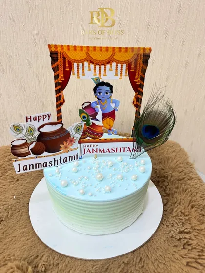 Another one of my designs for Janmashtami, this cake features a festive topper with little Krishna, a real peacock feather, and pearl-like sprinkles on a light blue frosting.