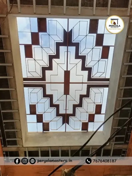 This skylight features a bold, symmetrical geometric pattern with colored accents. The design is reminiscent of stained glass but with a modern twist, creating a colorful and artistic light source for the room.