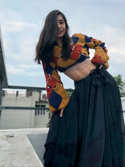 This full-length view shows how the #NoorTop pairs beautifully with a flowing black skirt. The cropped length and voluminous sleeves create a balanced and fashionable silhouette.