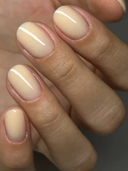 A close-up of our flawless Russian manicure featuring a creamy, jelly-nude polish. The precision around the cuticle is what sets our service apart.