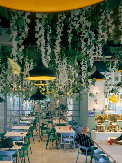 Another angle of the dining area. The combination of green and blue chairs adds a pop of color to the modern decor.