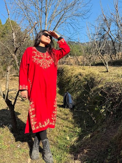 Soaking up the sun in a beautiful red Kashmiri Pheran. This traditional piece was not only warm but also added a vibrant touch to my mountain vacation wardrobe.