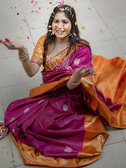 Another joyful shot with the flower petals, capturing the celebratory spirit of wearing a beautiful saree.