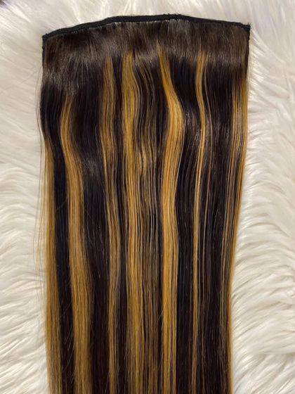 Our clip-in extensions with beautiful golden highlights, perfect for adding dimension and a sun-kissed look to your hair.