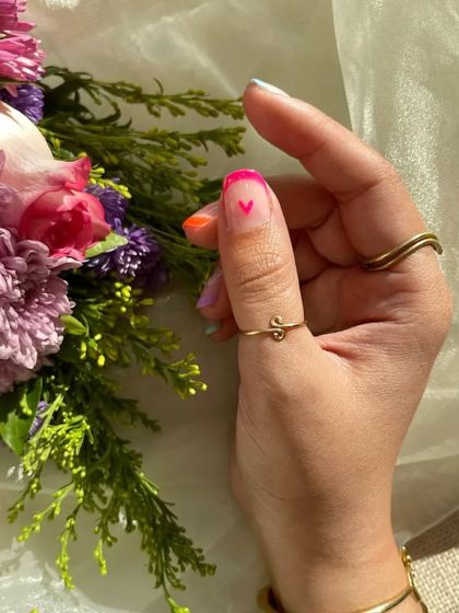 Valentine's Day special nails. This design features colorful French tips with tiny, hand-painted hearts.