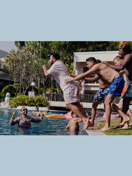 The groom gets playfully thrown into the pool by his friends during a pre-wedding party in Hua Hin, Thailand.