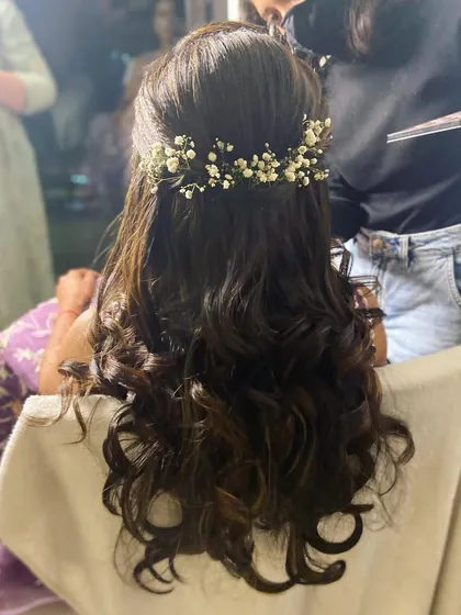 A back view of the Sangeet hairstyle. Soft curls gathered with a delicate baby's breath accessory for a touch of romance.