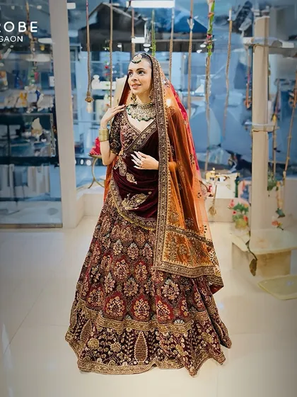 A full view of this exquisite designer wedding lehenga. The deep maroon velvet paired with detailed embroidery makes it a timeless piece for any bride.